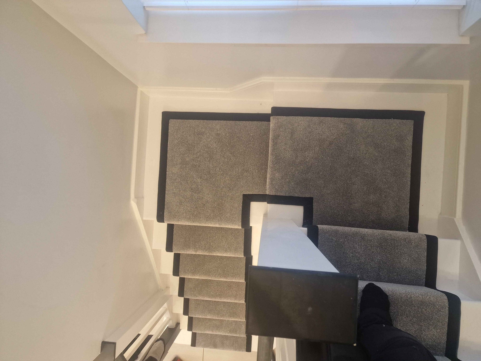 A hand-made, bespoke dark grey stair runner with a black cotton border