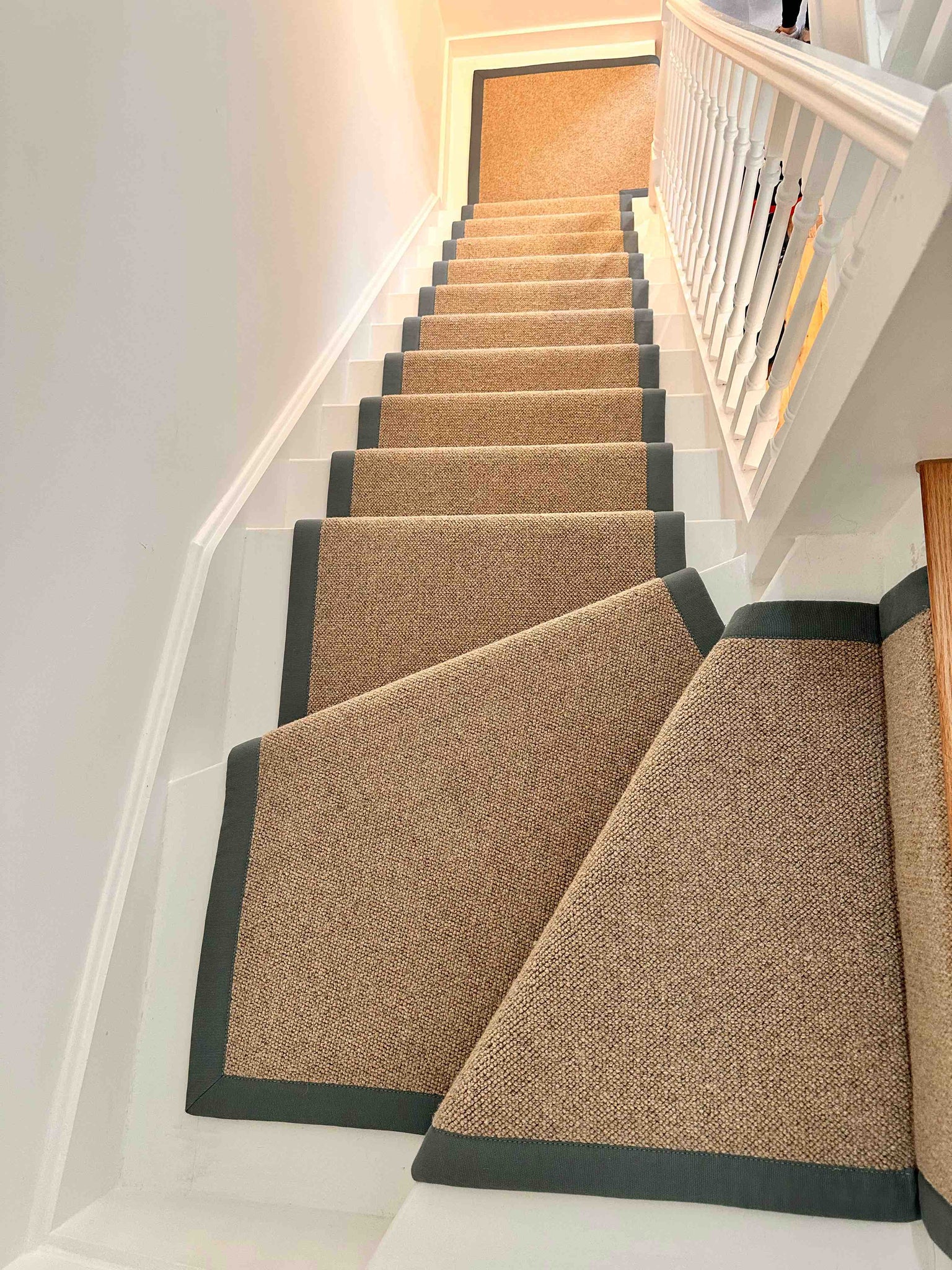 Wool loop pile stair runner with winding stairs and navy blue border in London