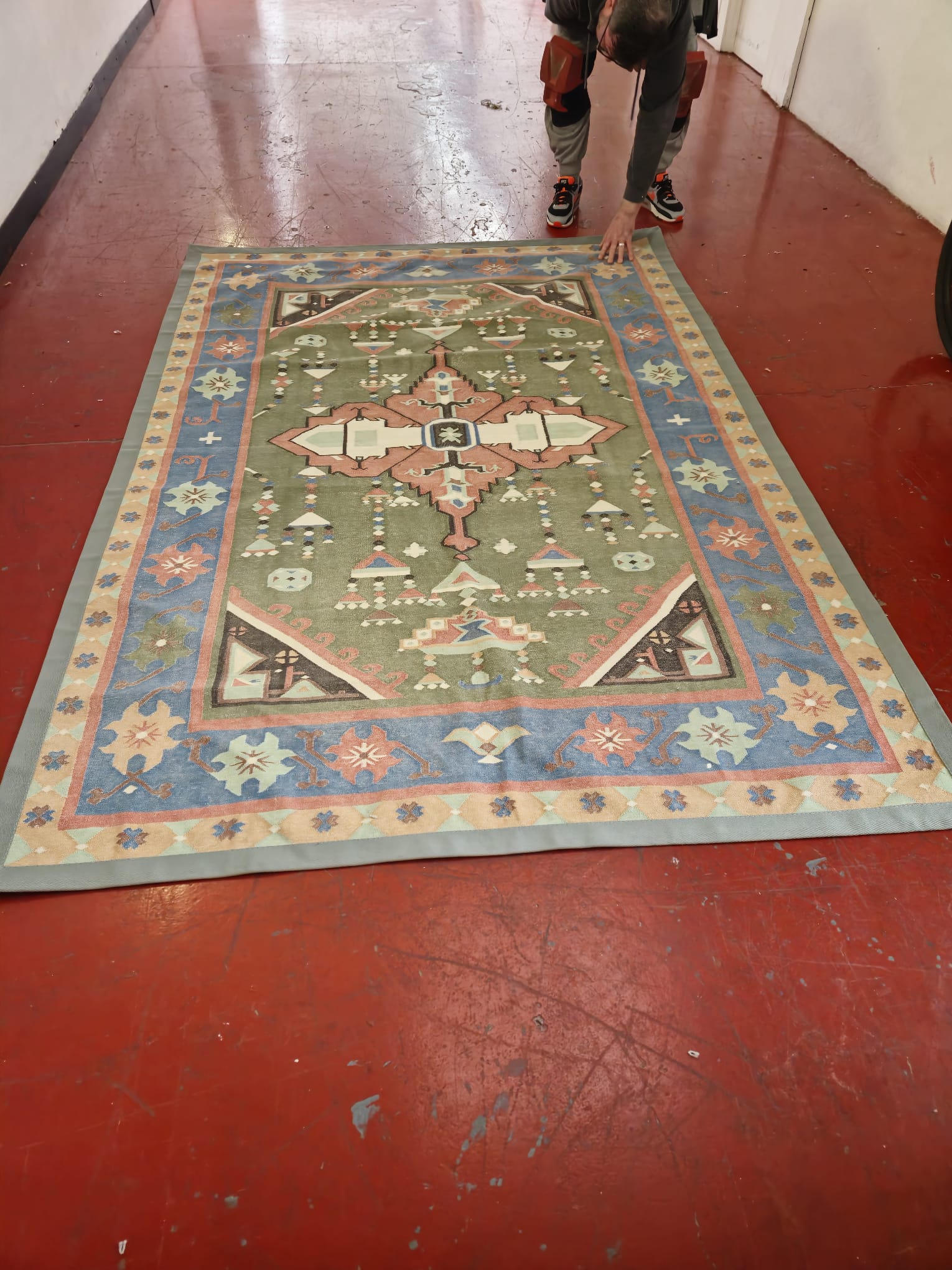 A new pale green cotton border sewn onto an old rug