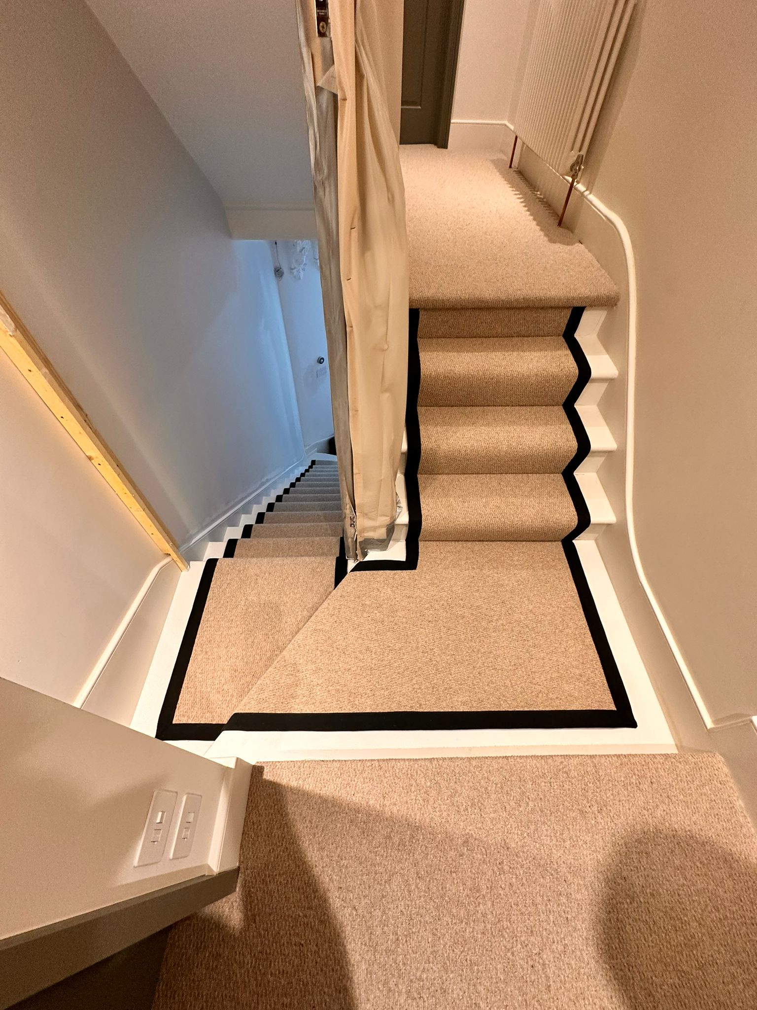 A bespoke wool carpet stair runner with a black border installed in Islington, London